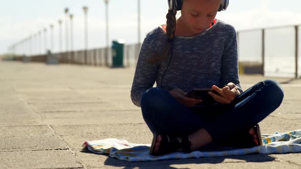Girl using digital tablet at beach