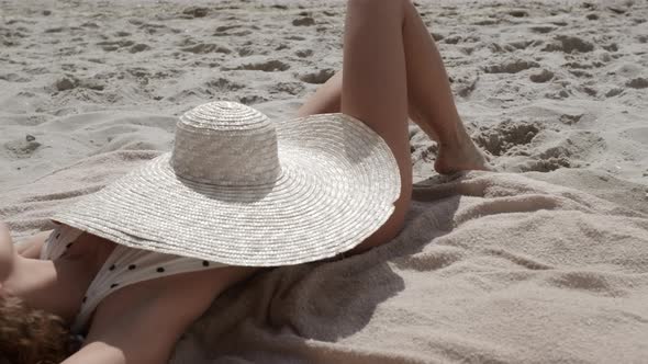 Brimmed Hat Covering Tanned Body of Gorgeous Woman Lying Sand Beach Close Up