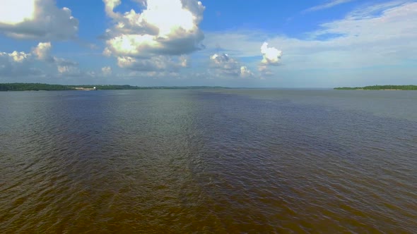 Low panning aerial shot over the meeting of the Black River and Amazon River