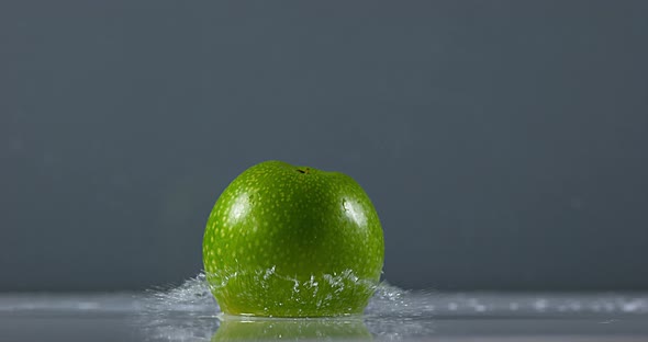 Granny Smith Apple, malus domestica, Fruit falling on Water against Black Background, Slow Motion 4K