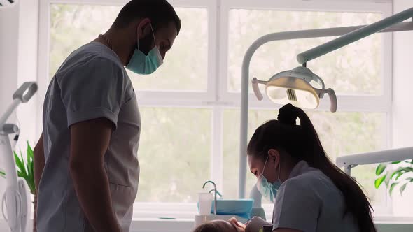 Two Dentists Perform an Operation in Dental Clinic