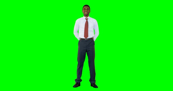 Businessman standing and smiling against green background