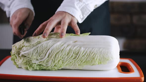 The Chef Is Cutting a Cauliflower on a Cutting Board