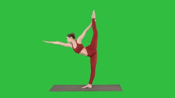 Slim woman standing in yoga pose dandayamana dhanurasana