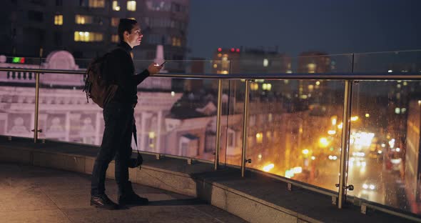 Man Using Smartphone Standing at Night City Terrace