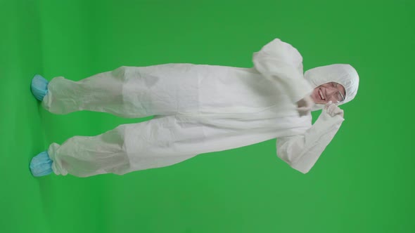 Full Body Of Asian Male Wearing Protective Uniform Ppe And Dancing In Green Screen Studio