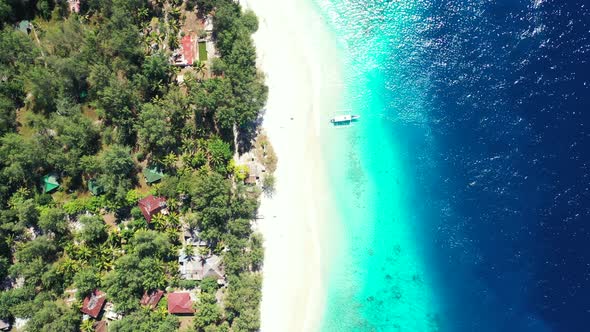 Wide angle flying tourism shot of a sandy white paradise beach and aqua turquoise water background i
