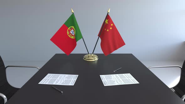 Flags of Portugal and China and Papers on the Table