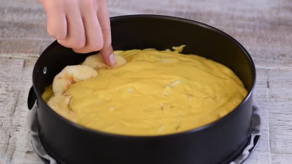 Baking Apple pie. Woman puts apple slices on a top of dough