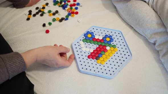 the Hands of a Child and an Adult Collect Flowers on a Plastic Mosaic