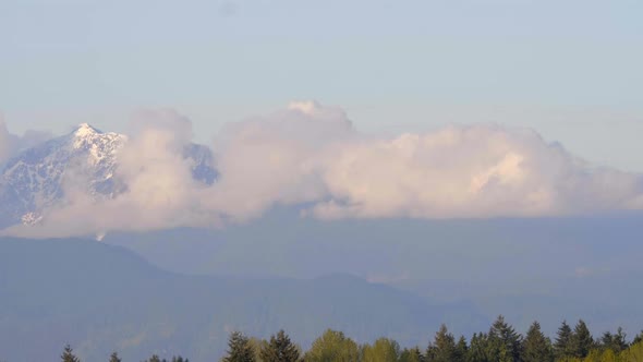 Clouds and Sky Time Lapse with Snowy Mountain Background. Sunny Day.