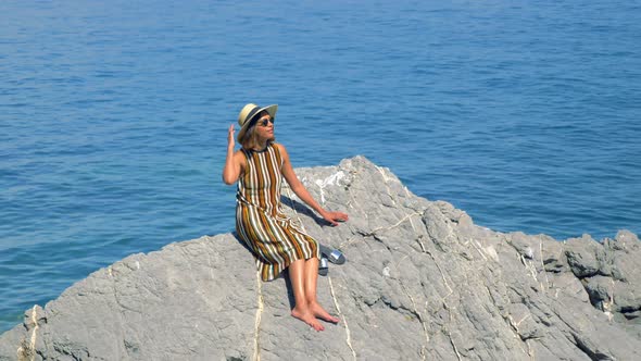 A woman on rocks traveling in a luxury resort town in Italy, Europe