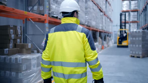 Follow footage of employees male warehouse worker engineer in hard hat working