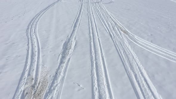 Flight over the tire marks in the snow 4K drone video