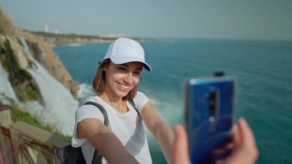 Attractive Smiling Woman Tourist Making Selfie on Mobile Phone on Lower Duden Waterfall Background