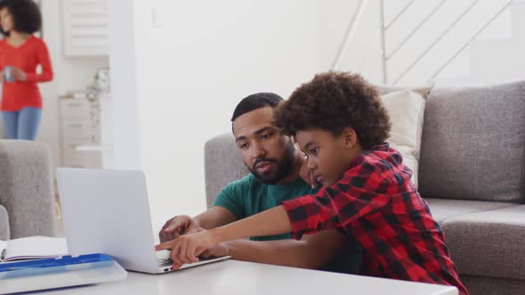 Father and son using laptop at home