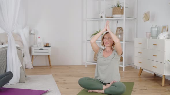 Young Woman Doing Yoga Exercises with Female Instructor at Home