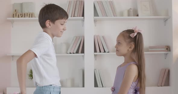 Caucasian Boy Giving Bouquet of Flowers To Shy Little Girl, Side View Portrait of Cute Gentleman