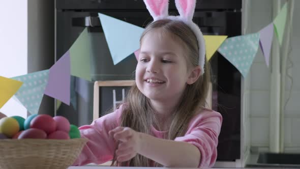 Child Steals a Basket of Eggs From the Table at Easter Day