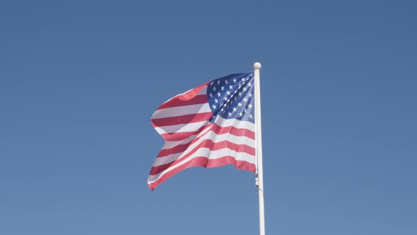 Famous United States of America flag fabric against blue sky 4K 2160 30fps UHD footage -  American s