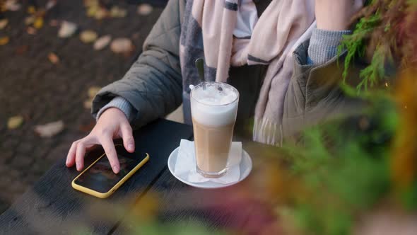 Woman Has Coffee Break in the Street Cafe and Watches the Photos in Her Phone  60p Slow Motion