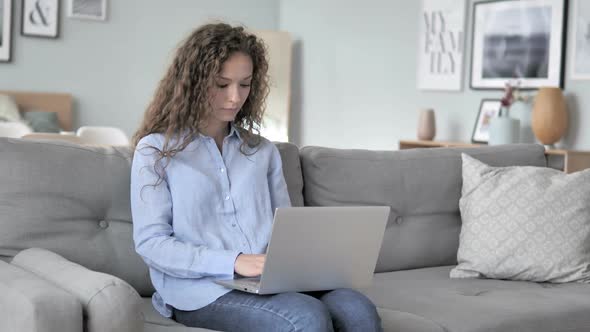 Curly Hair Woman Working On Laptop While Sitting on Couch