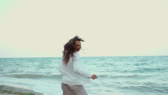 Motion Portrait Laughing Woman Holding Hand Boyfriend and Whirling By Wild Beach