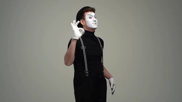 Portrait of Happy Male Mime Showing Okay and Thumbsup Hand Gestures and Winking Recommendation