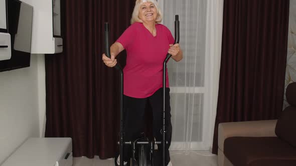 Healthy Elderly Senior Grandmother Model Exercising Sport Workout on Orbitrek in Room at Home