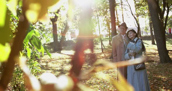 Elderly Married Couple Stands in Embraces Together Talks and Admires Autumn