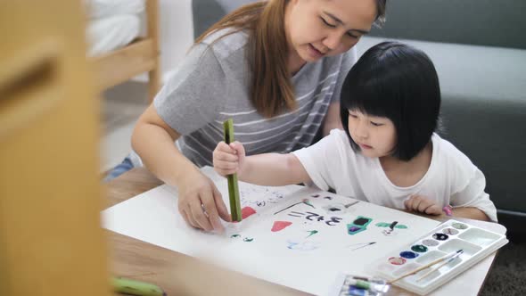 Happy Asian Mother and daughter together paint, Happiness moment at home.