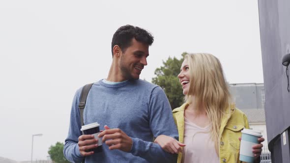 Front view of Caucasian couple on the go drinking a takeaway coffee