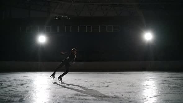 Training of Professional Single Female Figure Skater Young Woman is Skating Alone on Ice Rink Warmup