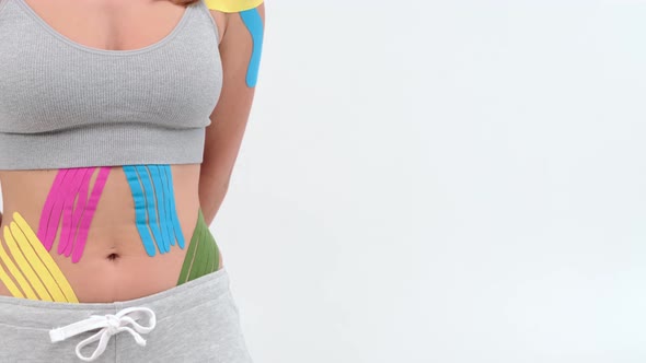 Kinesiology tape on girl belly. body with kinesio tape on the abdomen of young girl. Sport tratment