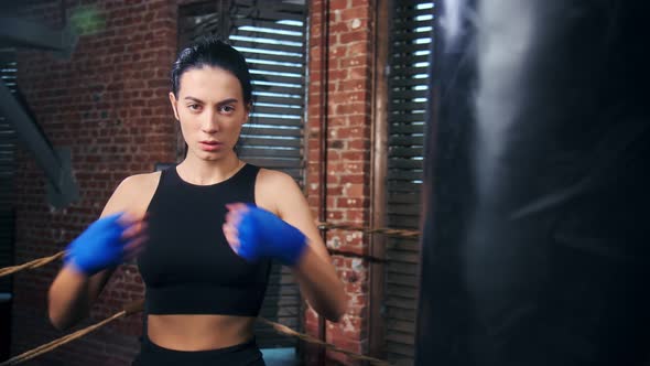 Fierce Brunette Female Professional Kickboxer with Wrapped Hand Ready to Training Battle Hitting Arm