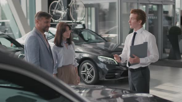 Car Salesman Talking and Shaking Hands with Customers