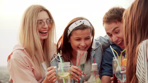 Friends on the Rooftop with Cocktails Loudly Having Fun, Screaming and Laughing