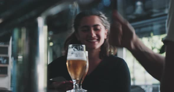 Women laughing and talking with his friends in a modern urban bar