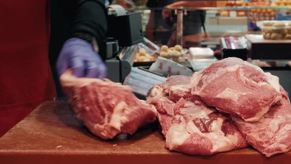 Hands with Knife of Smiling Butcher Cutting Meat at Counter in Butchery Pork Close Up