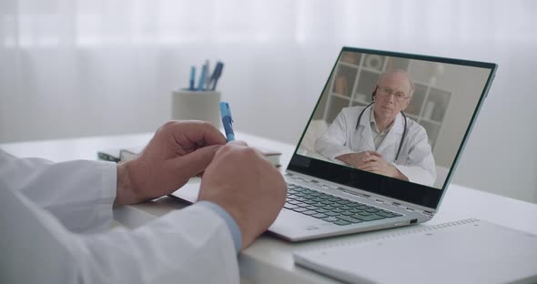 Two Therapists Are Consulting Online To Each Other By Videoconference From Their Offices in Clinics