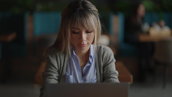 An Asian Business Woman Writes the Program Code of the Loya of Her Online Store