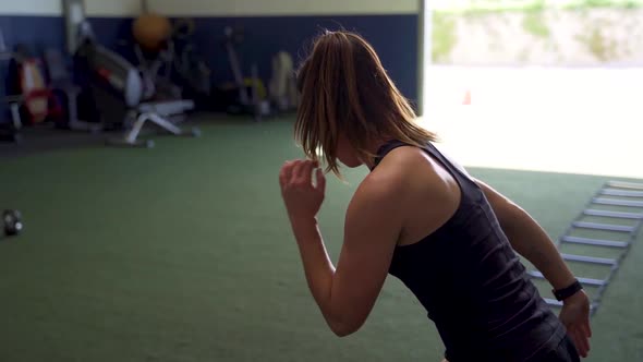 Female athlete performing ladder sprints alone in a gym