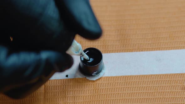 The Process of Tattooing a Man's Hand in a Tattoo Parlor