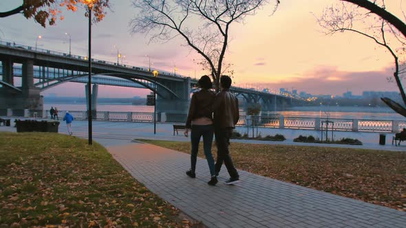 Two Lovers Are Walking Along the Embankment