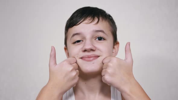 Positive Boy Holding Thumbs Up in Front of the Camera Showing a Sign of Consent