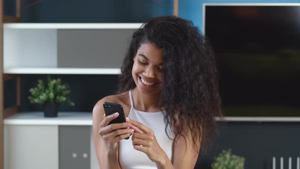 Young African Woman Using Smartphone Surfing Social Media, Checking News, Texting Messages and