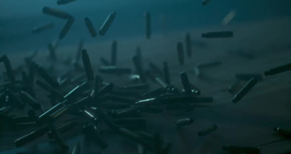 Lots of Bullets falling Down on water ground. War Concept. Professional Cinematic Slow Motion