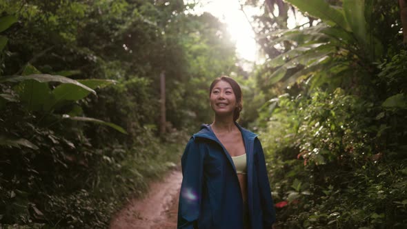 Young Female Explorer Smiling and Hiking in the Forest Mountain Trail
