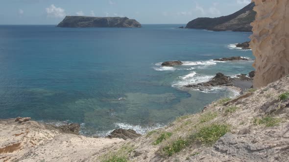 High angle of Porto dos Frades coast with rocky islet in background, Portugal. Static shot