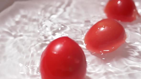 Slow motion fresh tomatoes drop into fresh water cleaning Concept It looks optimistic and healthy.